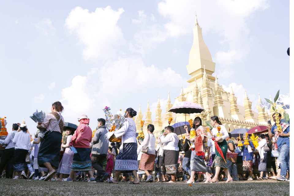Người dân Lào trong trang phục truyền thống trong lễ rước Pasatpheung (Rước tháp), một trong những lễ chính mở đầu cho phần lễ hàng năm trong lễ hội Thatluang. (Ảnh: Phạm Kiên-Bá Thành/TTXVN)