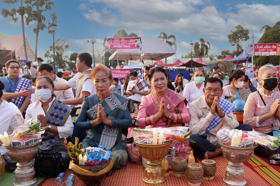 Đông đảo Phật tử Lào tụng kinh trước khi đến giờ thực hiện nghi lễ Xaybath (Cúng dường), một trong những nghi lễ được thực hiện trong suốt hai ngày lễ Thatluang. (Ảnh: Phạm Kiên-Bá Thành/TTXVN)