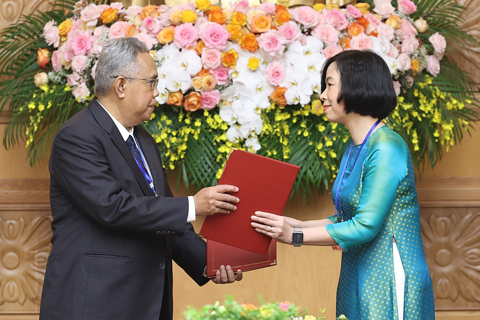 Tổng Giám đốc Thông tấn xã Việt Nam Vũ Việt Trang và Tổng biên tập Hãng thông tấn quốc gia Malaysia (BERNAMA) Khairdzir Md Yunus trao đổi Thỏa thuận hợp tác nghiệp vụ giữa Thông tấn xã Việt Nam và Hãng thông tấn quốc gia Malaysia. (Ảnh: Dương Giang/TTXVN)