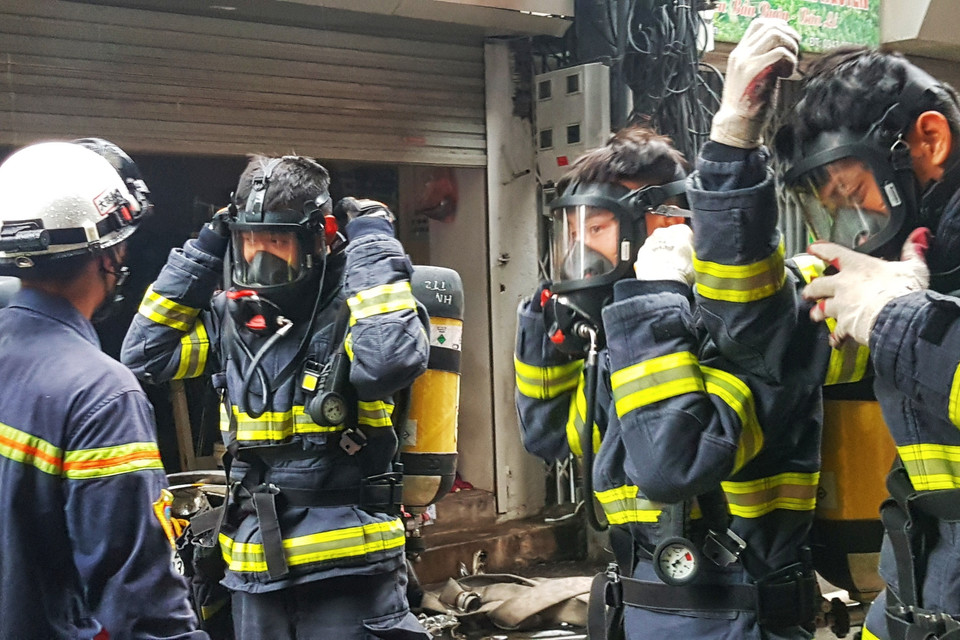 Các cán bộ chiến sỹ PCCC mặc trang bị bảo hộ để chuẩn bị tiếp cận hiện trường đám cháy. (Ảnh: Tuấn Anh/TTXVN)