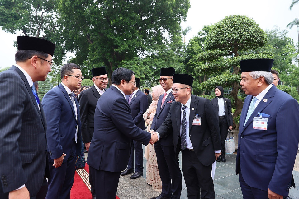 Thủ tướng Malaysia Anwar Ibrahim giới thiệu với Thủ tướng Phạm Minh Chính thành viên đoàn Malaysia. (Ảnh: Dương Giang/TTXVN)
