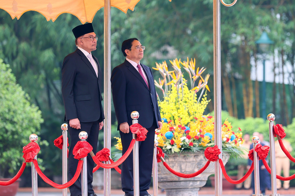 Thủ tướng Phạm Minh Chính và Thủ tướng Malaysia Anwar Ibrahim nghe quân nhạc cử quốc thiều hai nước. (Ảnh: Dương Giang/TTXVN)