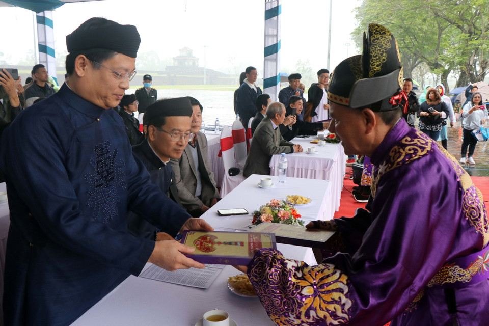 Tặng lịch Năm mới 2023 cho các đại biểu tham dự Lễ Ban Sóc triều Nguyễn. (Ảnh: Đỗ Trưởng/TTXVN)