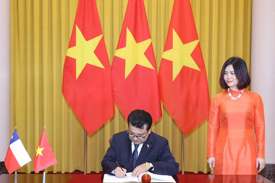 Đại sứ Chile Sergio Narea Guzmán viết lưu bút vào Sổ vàng lưu niệm. (Ảnh: Thống Nhất/TTXVN)