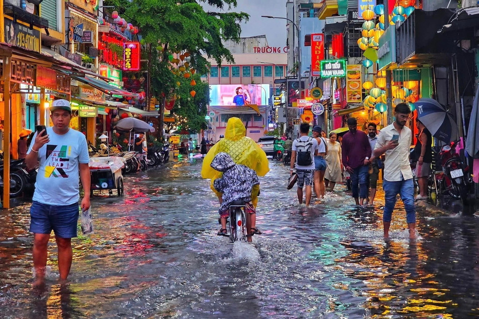 Du khách lội nước tại Phố đi bộ Bùi Viện (quận 1). (Ảnh: Hồng Giang/TTXVN)