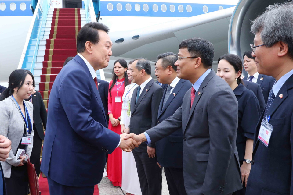 Thứ trưởng Ngoại giao Nguyễn Minh Vũ đón Tổng thống Hàn Quốc Yoon Suk Yeol và Phu nhân tại sân bay quốc tế Nội Bài. (Ảnh: An Đăng/TTXVN)