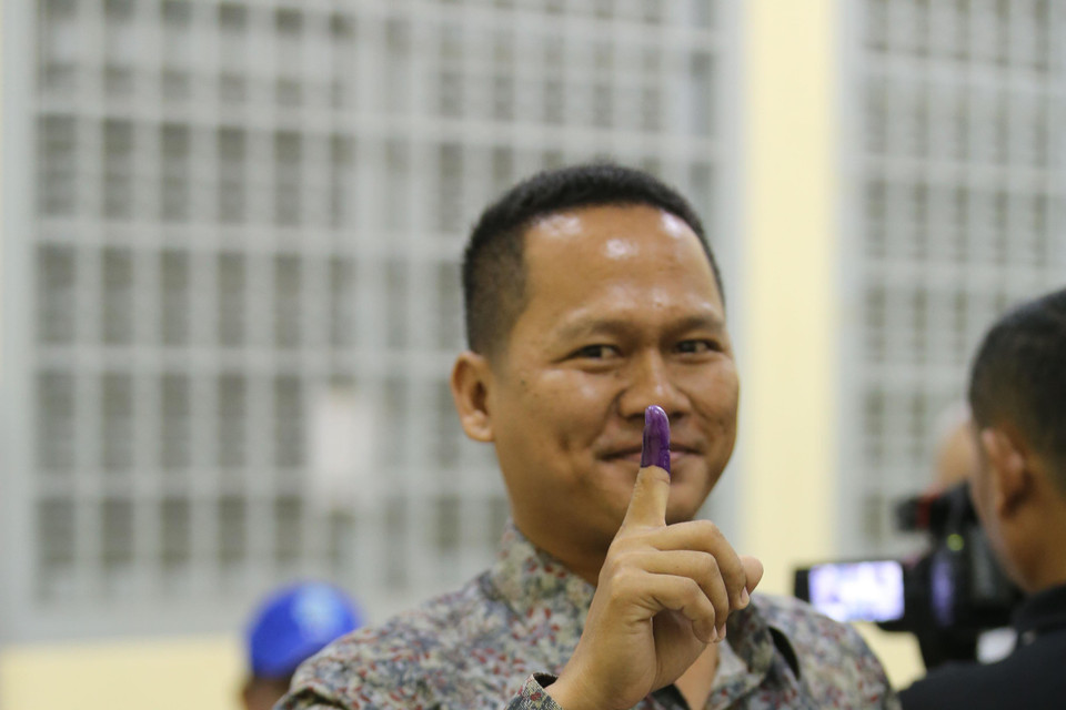 Cử tri giơ ngón tay có mực đánh dấu đã bầu cử. (Nguồn: Vietnam+)