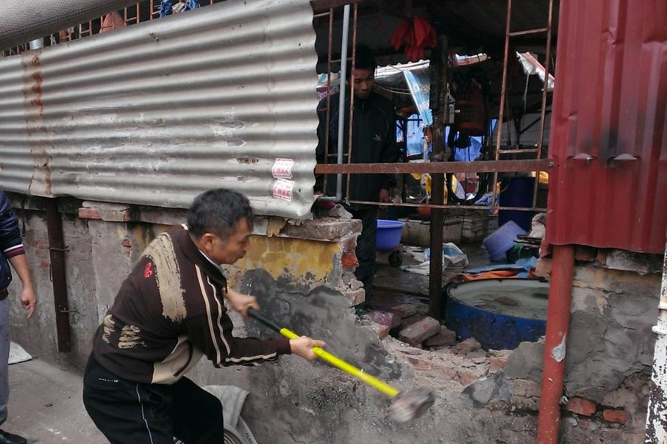 Người dân tiến hành đập tường để xử lý vụ cháy. (Ảnh: PV/Vietnam+)