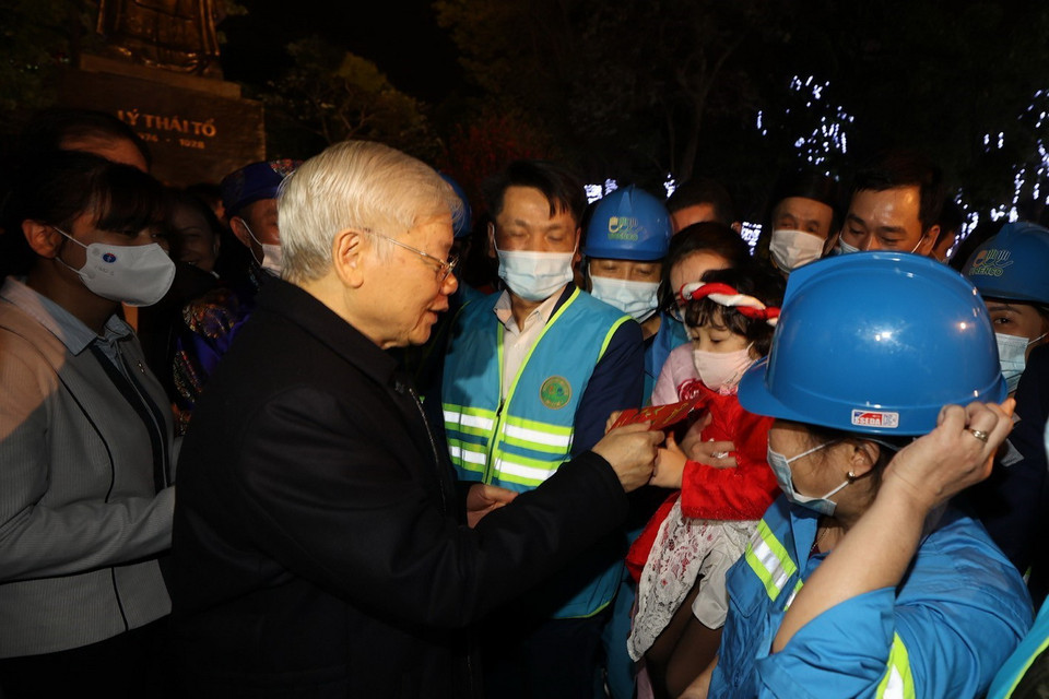 Tổng Bí thư, Chủ tịch nước Nguyễn Phú Trọng với cháu bé và người lao động Thủ đô tại Tượng đài Lý Thái Tổ. (Ảnh : Trí Dũng/TTXVN)