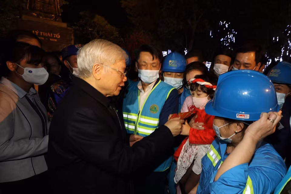 Tổng Bí thư, Chủ tịch nước Nguyễn Phú Trọng với cháu bé và người lao động Thủ đô tại Tượng đài Lý Thái Tổ. (Ảnh : Trí Dũng/TTXVN)