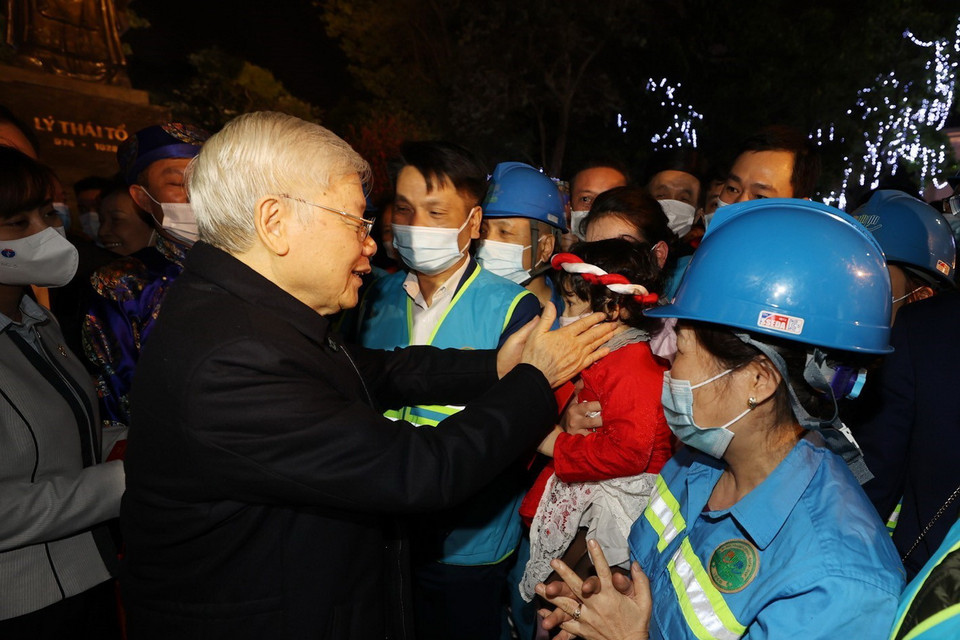  Tổng Bí thư, Chủ tịch nước Nguyễn Phú Trọng với cháu bé và người lao động Thủ đô tại Tượng đài Lý Thái Tổ. (Ảnh : Trí Dũng/TTXVN)