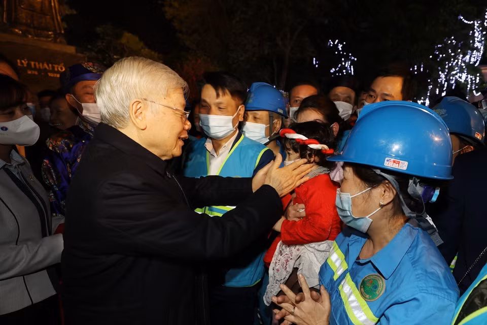  Tổng Bí thư, Chủ tịch nước Nguyễn Phú Trọng với cháu bé và người lao động Thủ đô tại Tượng đài Lý Thái Tổ. (Ảnh : Trí Dũng/TTXVN)