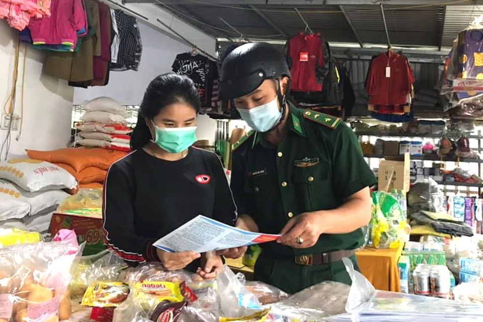 Chiến sỹ biên phòng Quảng Trị phát tờ rơi đến người dân, tuyên truyền phòng, chống dịch COVID-19. (Ảnh: TTXVN phát)