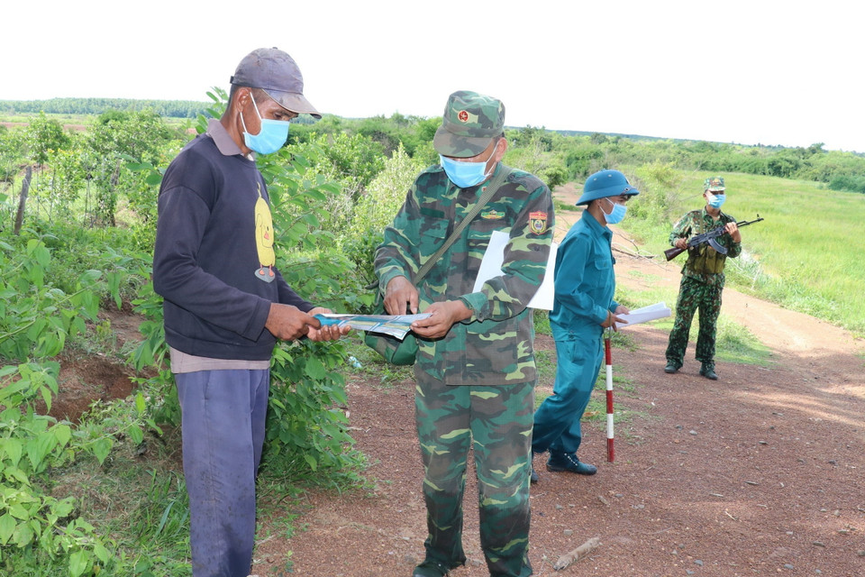 Tổ tuần tra biên giới và kiểm soát dịch bệnh COVID-19, thuộc Đồn biên phòng Lộc An (Bình Phước) tuyên truyền cho người dân về quy chế biên giới. (Ảnh: Sỹ Tuyên/TTXVN)