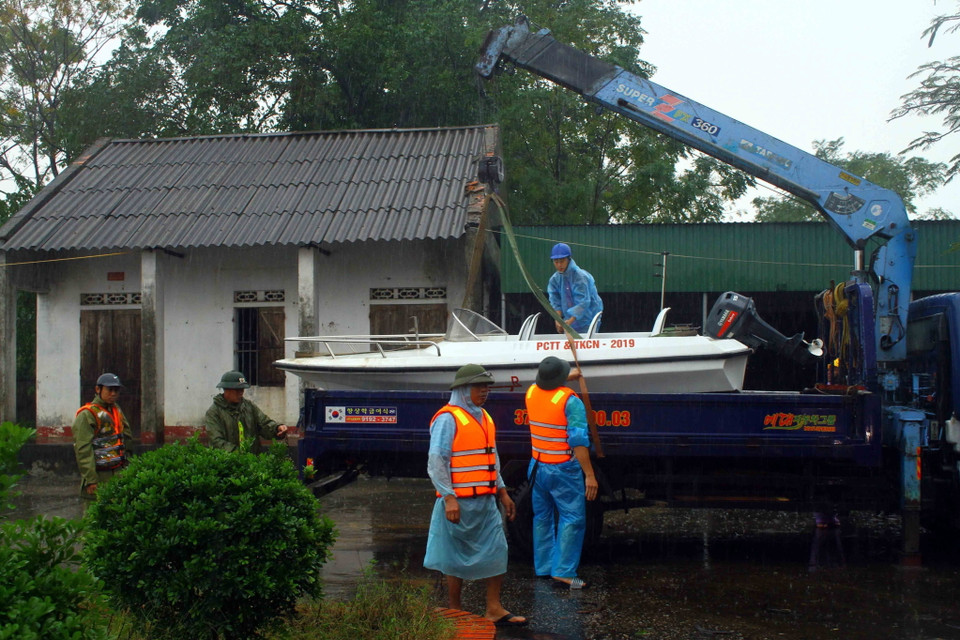 Lực lượng chức năng vận chuyển cano để triển khai công tác cứu hộ cứu nạn tại xã Châu Nhân, huyện Hưng Nguyên (Nghệ An), nơi có 1.000 hộ dân đang bị ngập sâu. (Ảnh: Tá Chuyên/TTXVN)