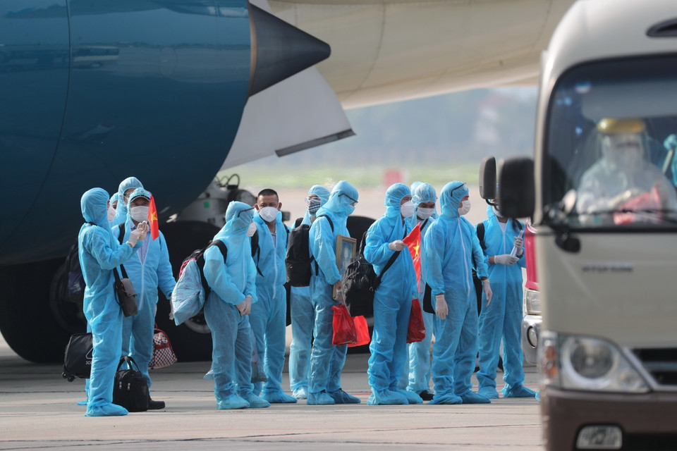 Các công dân xuống máy bay vào xe để về khu cách ly y tế. (Ảnh: Thành Đạt/TTXVN)