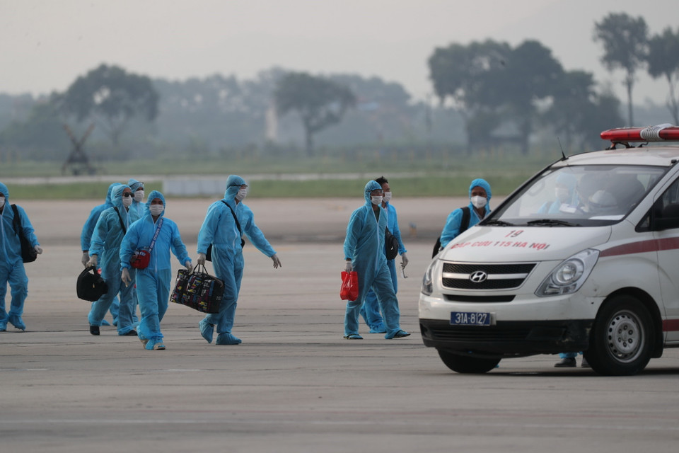 Các công dân xuống máy bay vào xe để về khu cách ly y tế. (Ảnh: Thành Đạt/TTXVN)