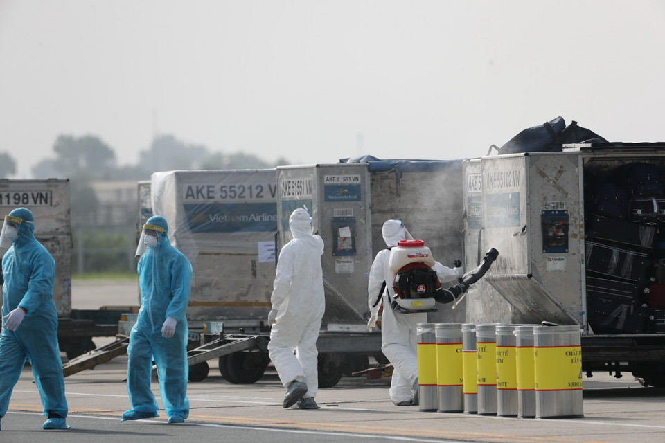 Toàn bộ hành lý của chuyến bay được phun khử trùng ngay khi chuyển ra khỏi máy bay. (Ảnh: Thành Đạt/TTXVN)