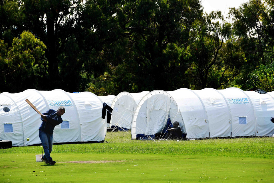 Một người vô gia cư tranh thủ chơi môn bóng chày tại một khu nhà tạm dành cho người không nhà cửa tại thủ đô Pretoria. (Ảnh: Phi Hùng/TTXVN)