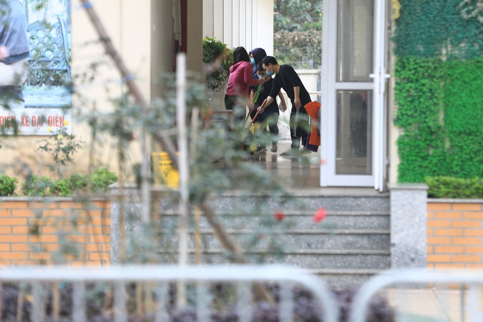 ác phụ huynh và học sinh cùng nhau lau chùi, vệ sinh chỗ ở tại khu cách ly tập trung trường Tiểu học Xuân Phương. (Ảnh: Thành Đạt/TTXVN)