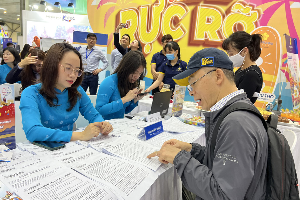 Du khách tìm hiểu thông tin những điểm đến mới. (Ảnh: Mai Mai/Vietnam+)