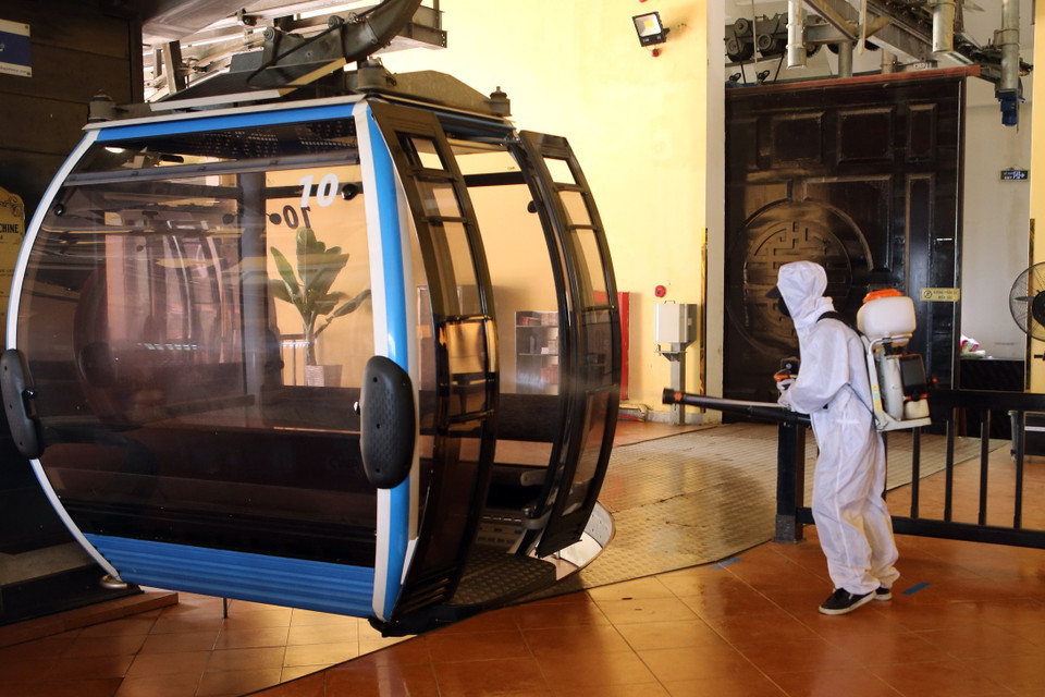 Phun khử khuẩn các ca bin cáp treo đưa khách lên Khu du lịch Bà Nà Hills. (Ảnh: Trần Lê Lâm/TTXVN)