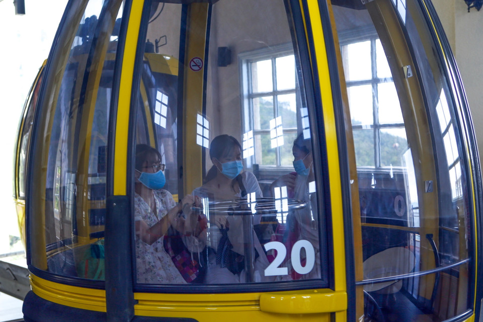 Mỗi cabin chỉ chở 1/2 số người theo quy định và phải đeo khẩu trang để phòng chống dịch tại Khu du lịch Bà Nà Hills. (Ảnh: Trần Lê Lâm/TTXVN)