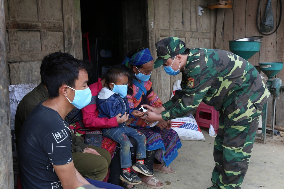 Cán bộ, chiến sỹ Đồn Biên phòng Pha Long, Bộ đội Biên phòng Lào Cai phát và hướng khử khuẩn phòng dịch cho người dân địa phương. (Ảnh: Dương Giang/TTXVN)