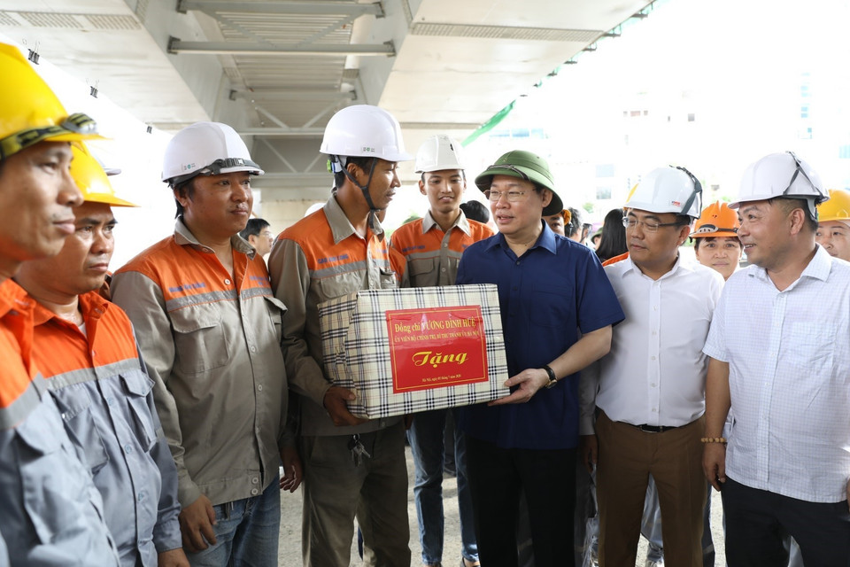 Bí thư Thành ủy Hà Nội Vương Đình Huệ tặng quà cán bộ, công nhân tại Dự án xây dựng cầu vượt, nút giao giữa đường Hoàng Quốc Việt với đường Nguyễn Văn Huyên. (Ảnh: Văn Điệp/TTXVN)