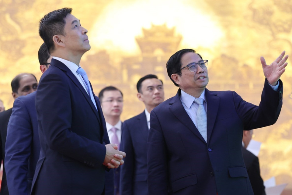 Thủ tướng Phạm Minh Chính giới thiệu với Chủ tịch Quốc hội Singapore Tan Chuan-Jin về kiến trúc của Trụ sở Chính phủ. (Ảnh: Dương Giang/TTXVN)