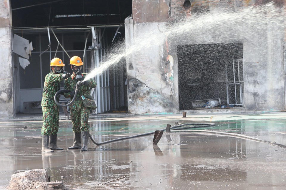 Lực lượng Binh chủng Hóa học phun hóa chất tẩy độc mặt nền nhà xưởng của Công ty Rạng Đông, ngày 5/10. (Ảnh: Dương Giang/TTXVN)