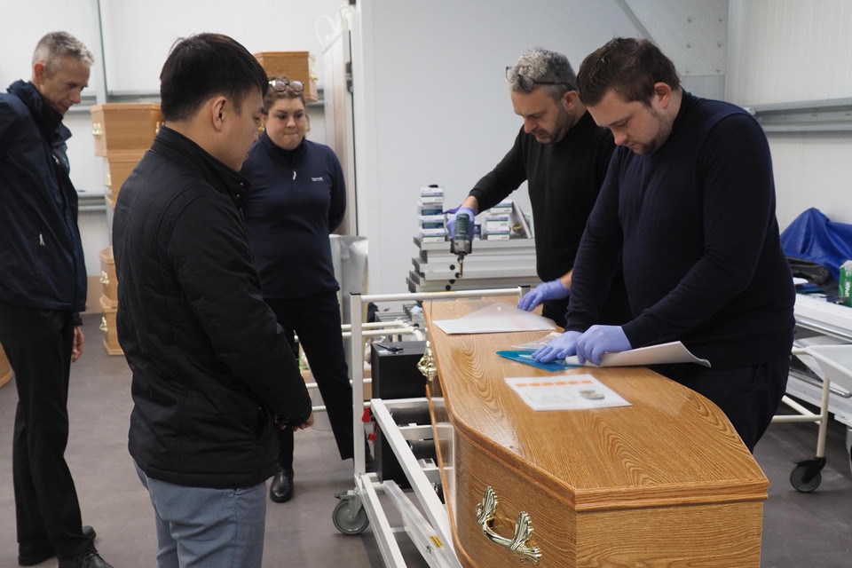 Đại diện Đại sứ quán Việt Nam tại Anh cùng lực lượng chức năng kiểm tra thông tin nạn nhân trước khi làm thủ tục chuyển ra sân bay. (Ảnh: Nhóm PV TTXVN tại Anh)