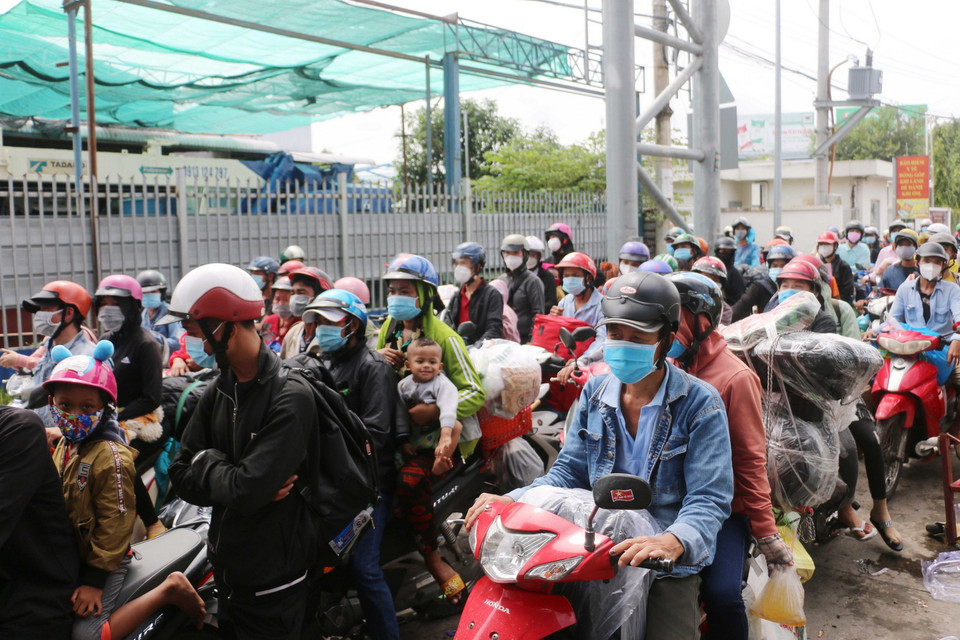 Số lượng người dân về quê tự phát nối hàng dài chờ được cho qua chốt kiểm soát dịch bệnh T2 của thành phố Long Xuyên để thực hiện cách ly tập trung gây ách tắc giao thông cục bộ tại cửa ngõ vào An Giang. (Ảnh: Công Mạo/TTXVN)