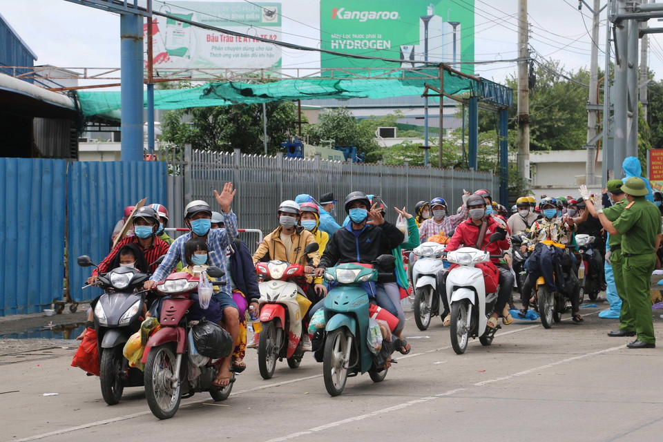 Người dân vui mừng vì được tỉnh An Giang tiếp nhận và đưa về các khu cách ly tạm thời, chờ sàng lọc, phân loại theo từng nhóm đối tượng, địa bàn cư trú sẽ được trước khi bàn giao cho các địa phương đón về cách ly tập trung theo quy định.(Ảnh: Công Mạo/TTXVN)