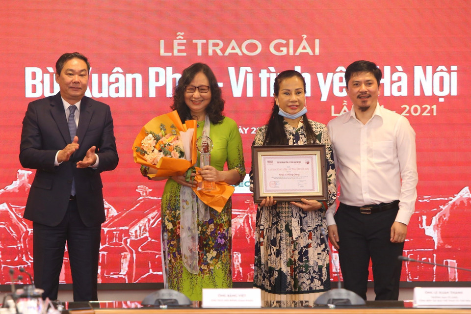 Phó Chủ tịch Thường trực Ủy ban Nhân dân thành phố Hà Nội Lê Hồng Sơn (bên trái) và Tổng Biên tập Báo Thể thao và Văn hoá Lê Văn Thành trao “Giải thưởng lớn - Vì tình yêu Hà Nội” cho đại diện gia đình nhạc sỹ Hồng Đăng. (Ảnh: Hoàng Hiếu/TTXVN)