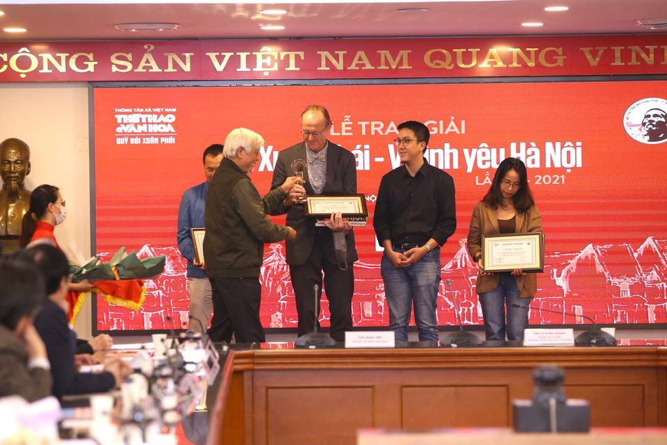 Tiến sỹ Sử học Dương Trung Quốc trao giải “Tác phẩm - Vì tình yêu Hà Nội” cho nhiếp ảnh gia Thomas Billhardt (tác giả Cuốn sách và triển lãm ảnh Hà Nội 1967-1975). (Ảnh: Hoàng Hiếu/TTXVN)