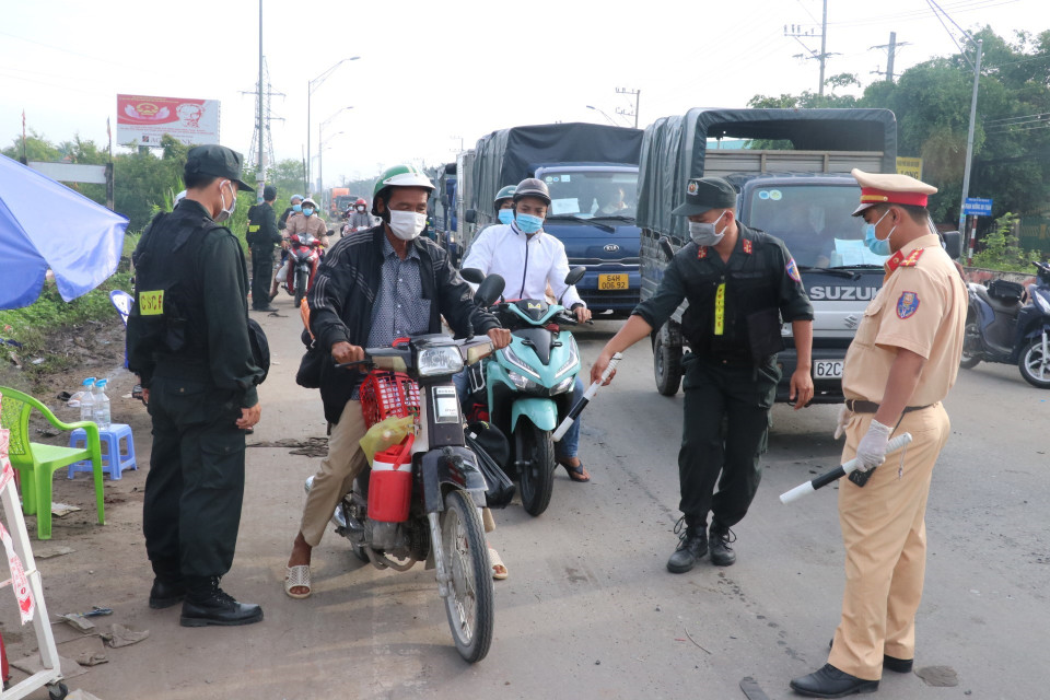 Lực lượng chức năng kiểm tra và giải quyết cho người dân qua chốt. (Ảnh: Bùi Giang/TTXVN)