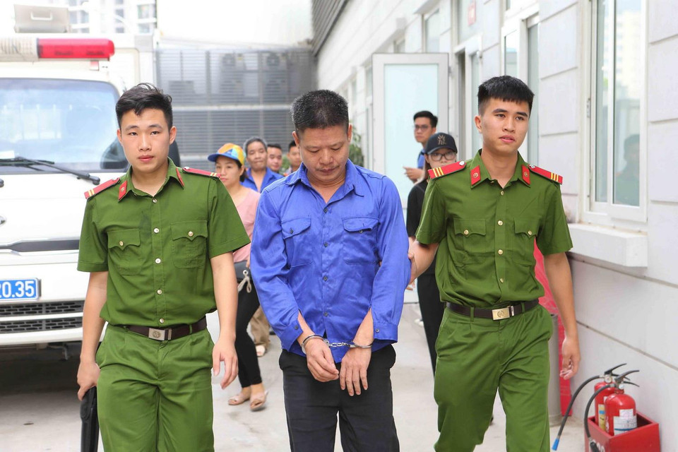 Cảnh sát dẫn giải các bị cáo vào phòng xét xử. (Ảnh: Doãn Tấn/TTXVN)