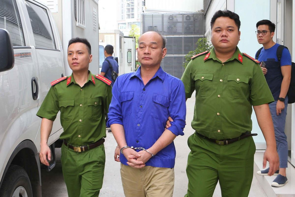 Cảnh sát dẫn giải các bị cáo vào phòng xét xử. (Ảnh: Doãn Tấn/TTXVN)