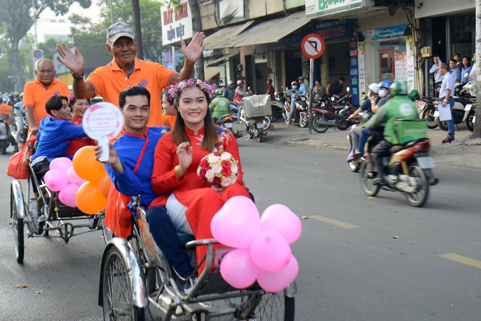Các cặp vợ chồng diễu hành trên đường phố bằng xe xích lô. (Ảnh: Xuân Khu/TTXVN)
