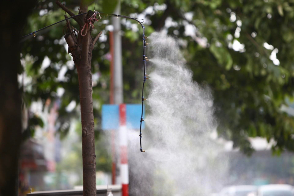 Nhiều cửa hàng ở Hà Nội phải sử dụng vòi phun sương để giảm nhiệt. (Ảnh: Minh Quyết/TTXVN)