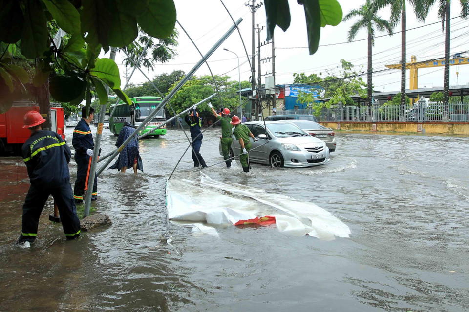 Biển quảng cáo bị đổ, đường phố bị ngập cục bộ, gây ảnh hưởng đến các phương tiện tham gia giao thông ở Hải Phòng. (Ảnh: An Đăng/TTXVN)