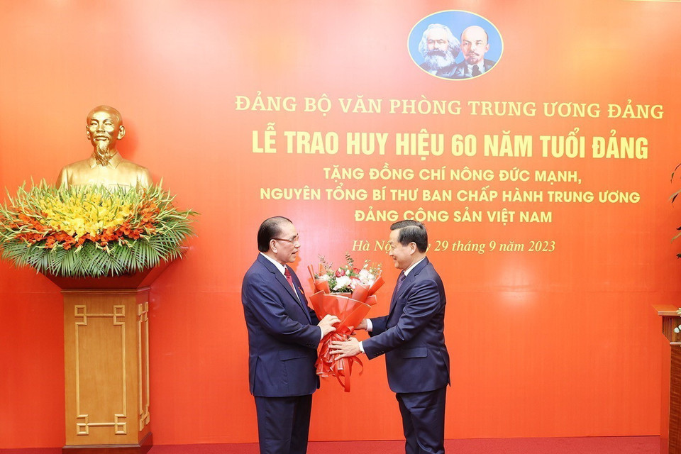 Đồng chí Lê Minh Khái, Bí thư Trung ương Đảng, Phó Thủ tướng Chính phủ, thay mặt Ban Cán sự Đảng Chính phủ chúc mừng nguyên Tổng Bí thư Nông Đức Mạnh. (Ảnh: Trí Dũng/TTXVN)