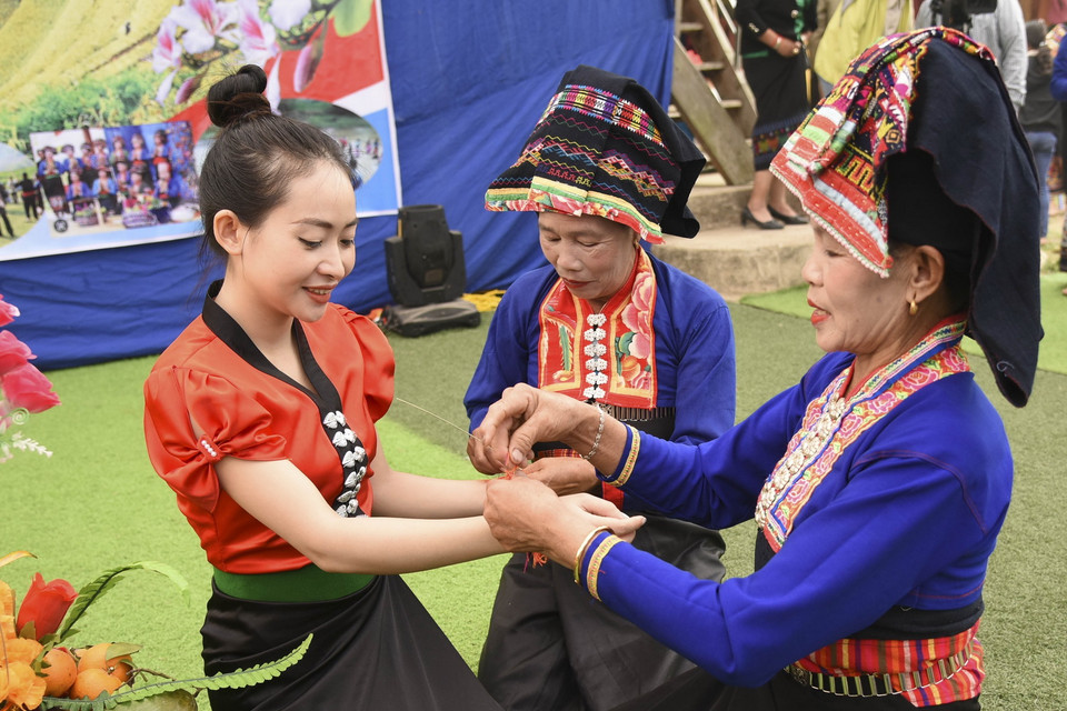  Buộc chỉ cổ tay là nghi thức không thể thiếu trong Tết té nước của người dân tộc Lào. (Ảnh: Xuân Tư/TTXVN)