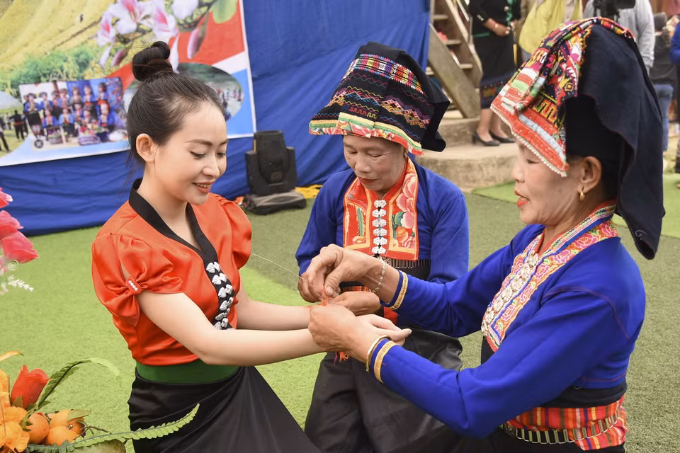  Buộc chỉ cổ tay là nghi thức không thể thiếu trong Tết té nước của người dân tộc Lào. (Ảnh: Xuân Tư/TTXVN)