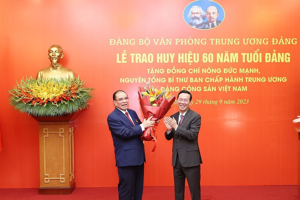 Đồng chí Võ Văn Thưởng, Ủy viên Bộ Chính trị, Chủ tịch nước, chúc mừng nguyên Tổng Bí thư Nông Đức Mạnh. (Ảnh: Trí Dũng/TTXVN)