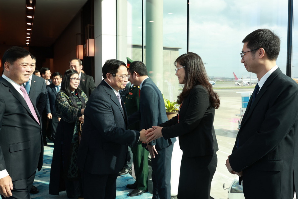 Cán bộ, nhân viên Đại sứ quán và cộng đồng người Việt Nam đón Thủ tướng Phạm Minh Chính tại sân bay Changi. (Ảnh: Dương Giang/TTXVN)