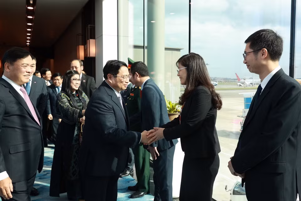 Cán bộ, nhân viên Đại sứ quán và cộng đồng người Việt Nam đón Thủ tướng Phạm Minh Chính tại sân bay Changi. (Ảnh: Dương Giang/TTXVN)