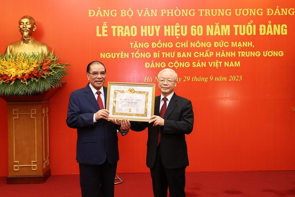 Tổng Bí thư Nguyễn Phú Trọng trao Huy hiệu 60 năm tuổi Đảng cho nguyên Tổng Bí thư Nông Đức Mạnh. (Ảnh: Trí Dũng/TTXVN)