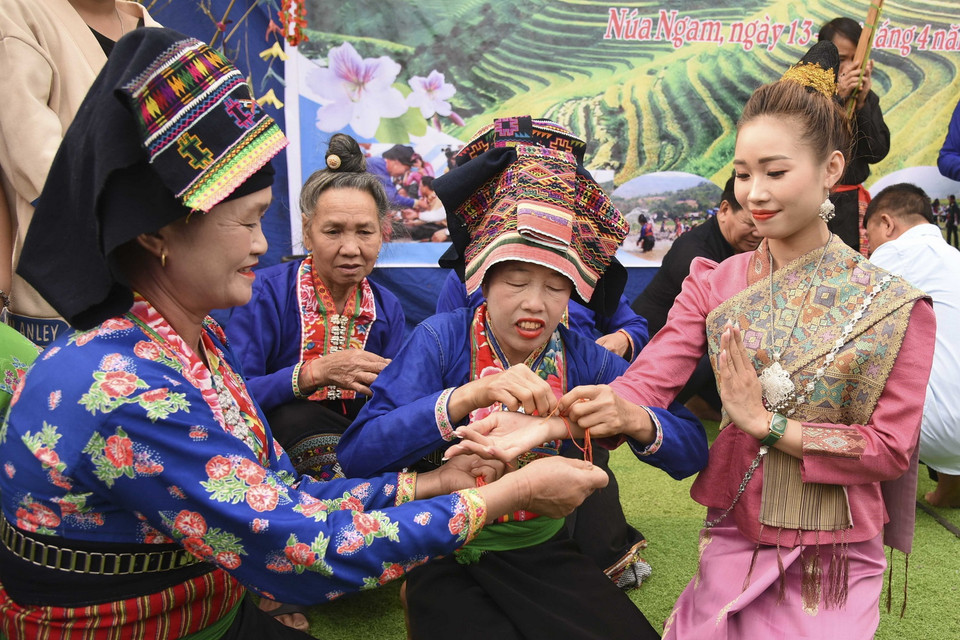  Nghi thức buộc chỉ cổ tay cầu may, chúc phúc cho người được buộc chỉ một năm mới bình an, không ốm đau bệnh tật. (Ảnh: Xuân Tư/TTXVN)